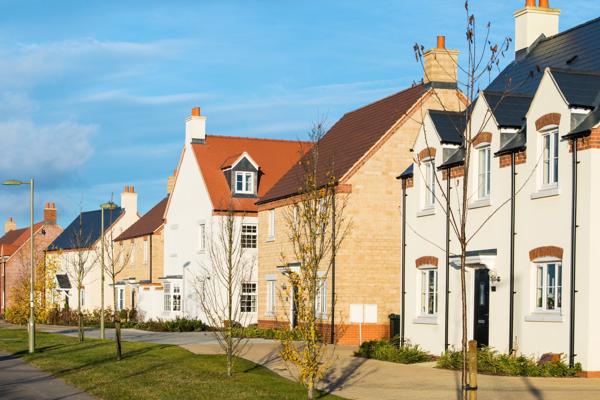 A row of houses in a residential area with a blue sky in the background.