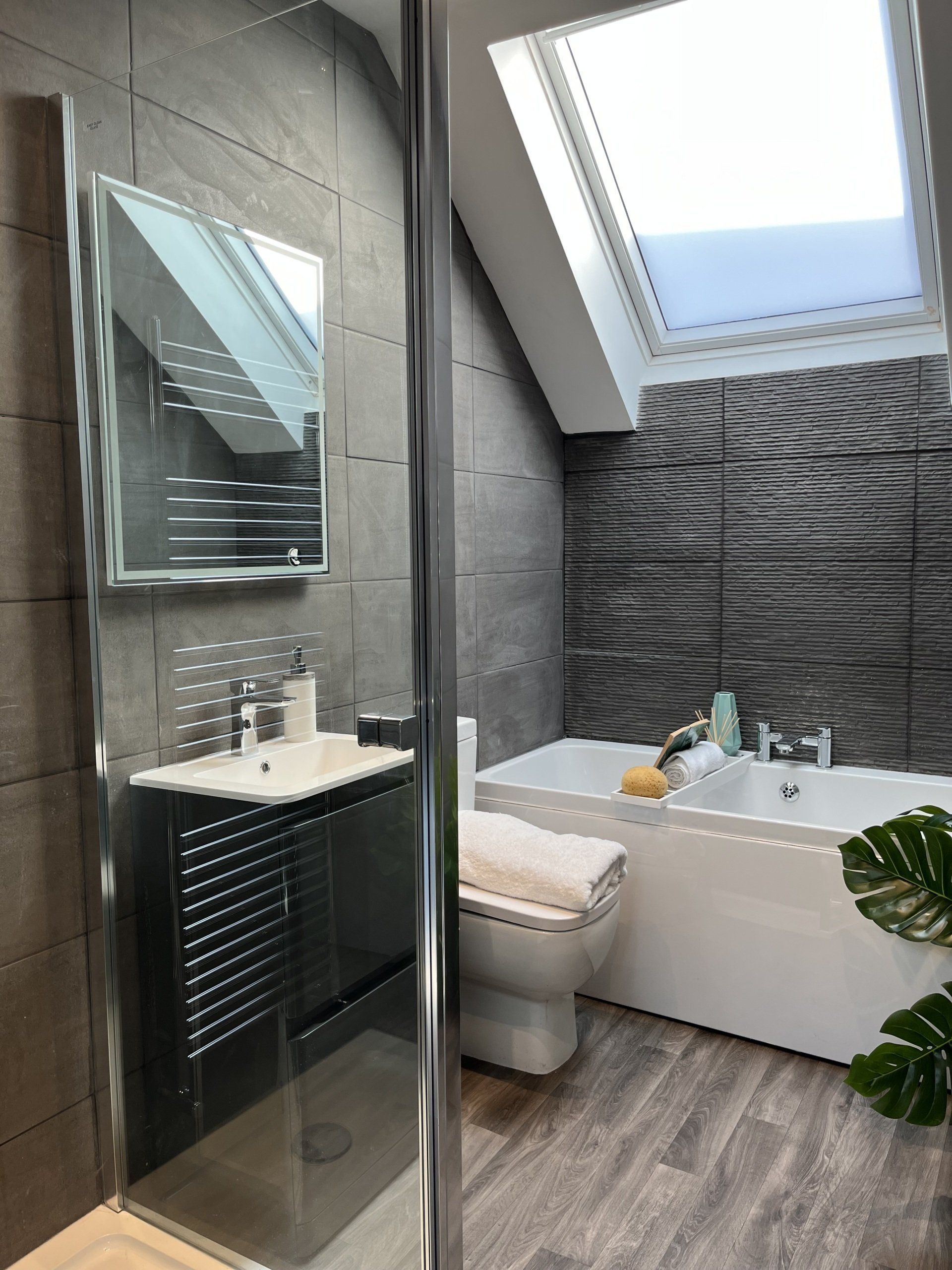 A bathroom with a bathtub , toilet , sink and mirror.