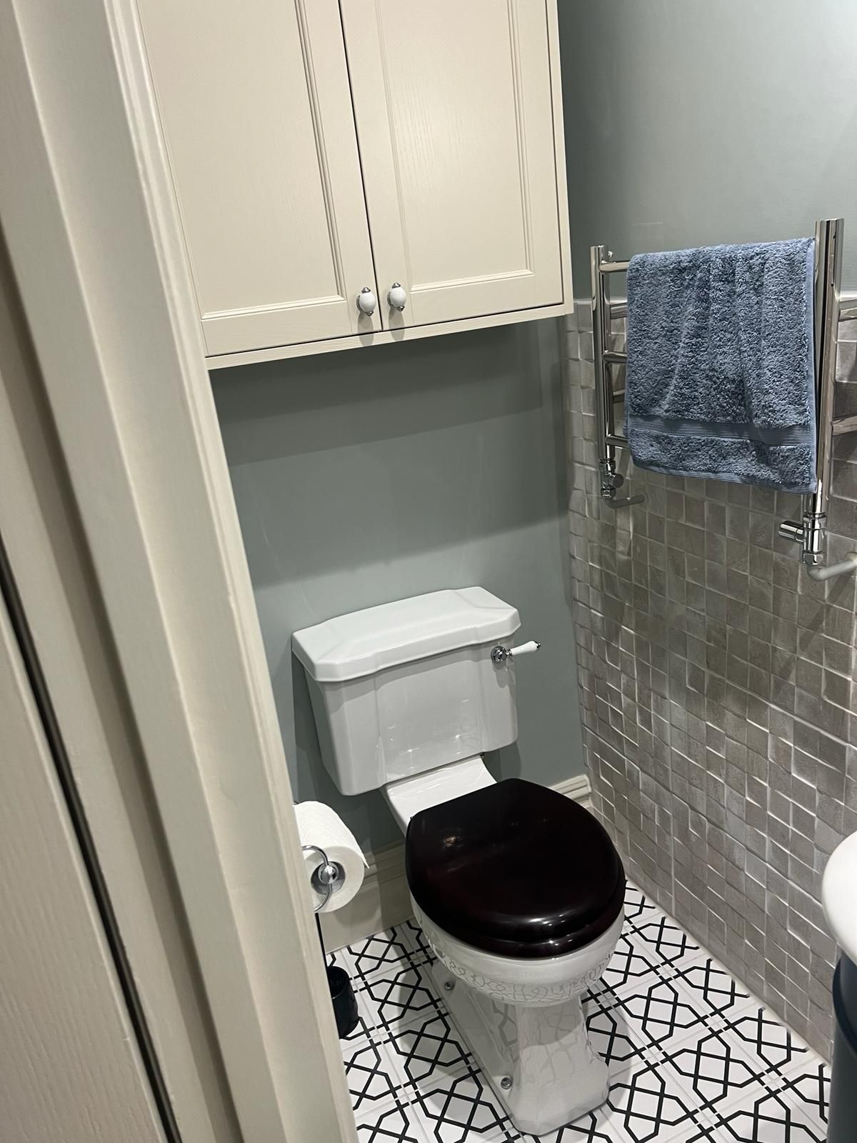 A bathroom with a toilet and a towel rack.