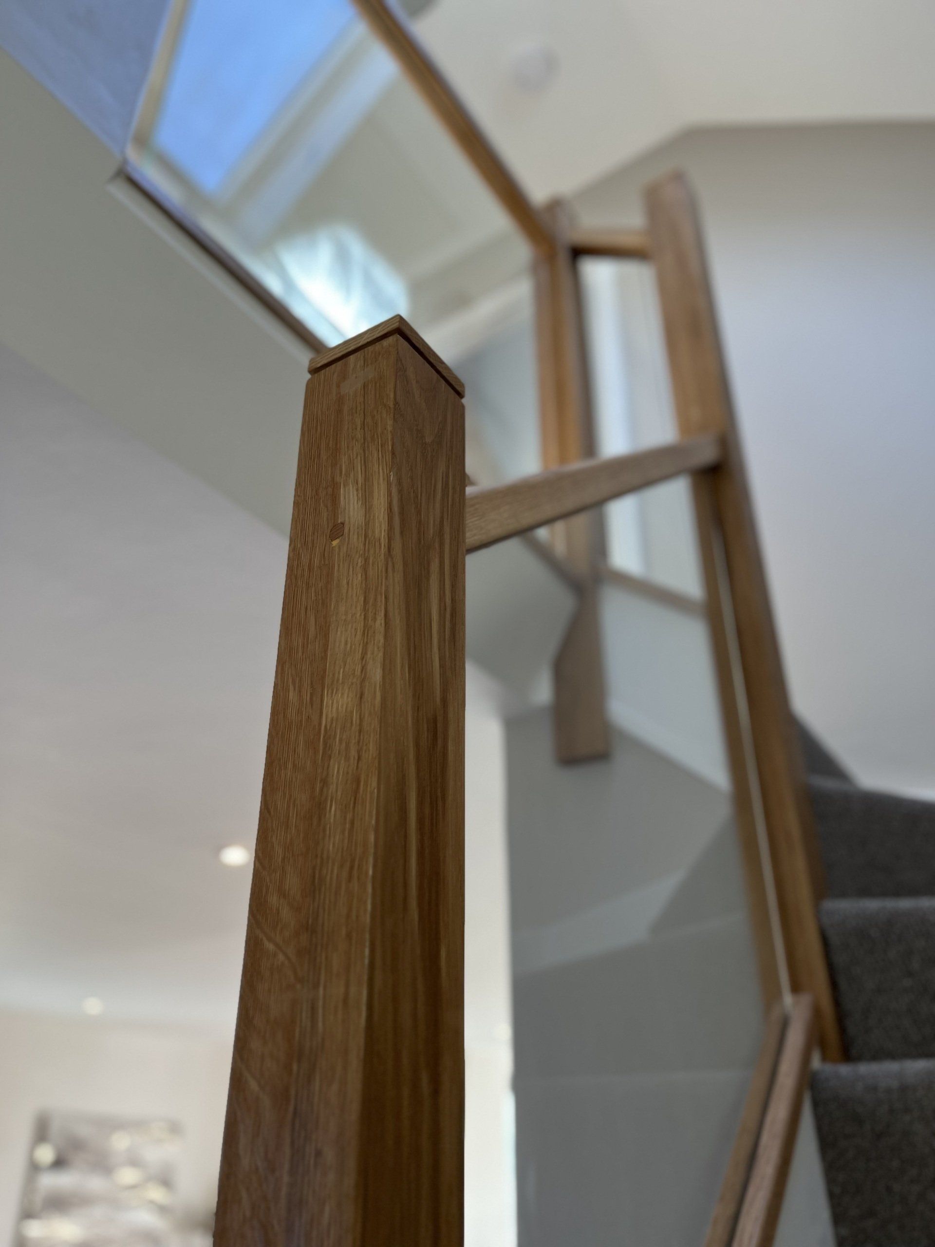 A staircase with a wooden railing and a glass railing