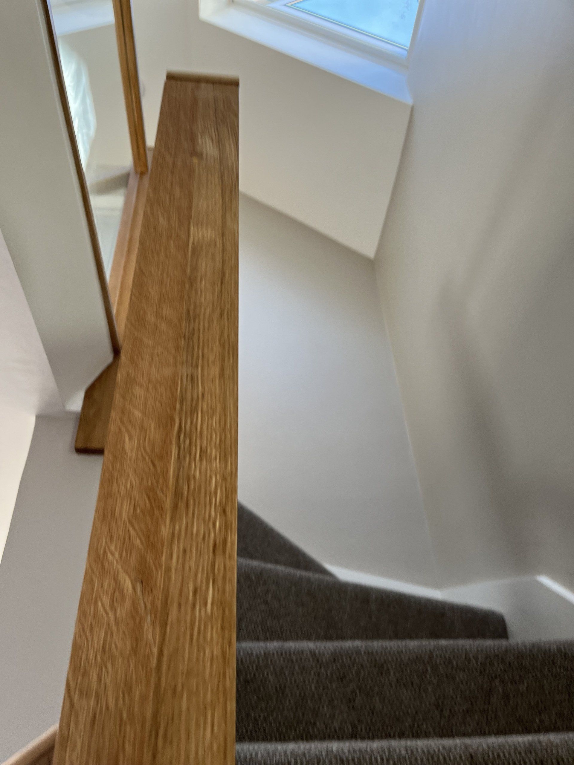 Looking up a set of stairs with a wooden railing