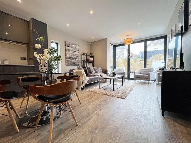 A living room with a couch , chairs , a table and a television.