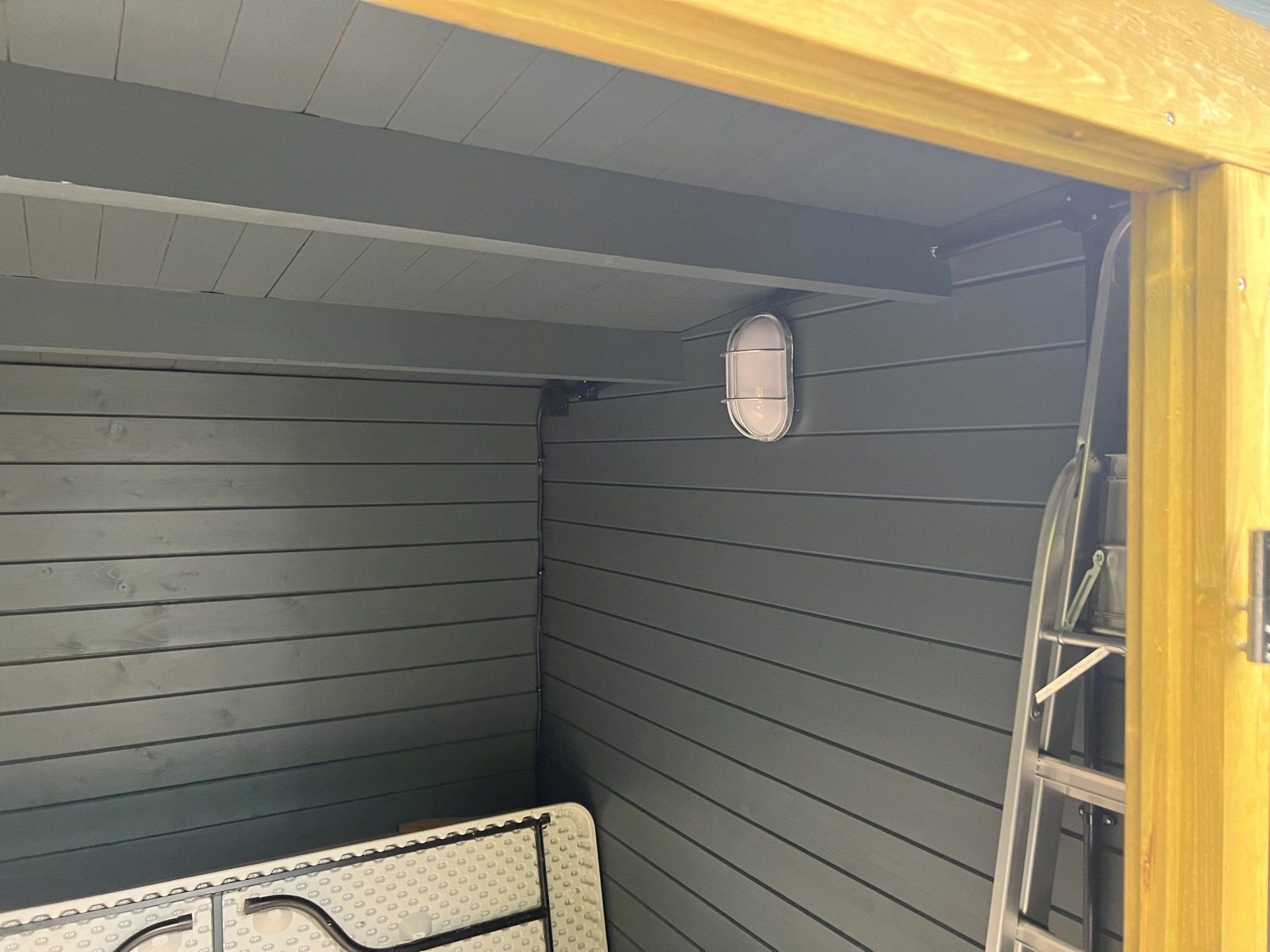 A room with a table and a ladder in it.