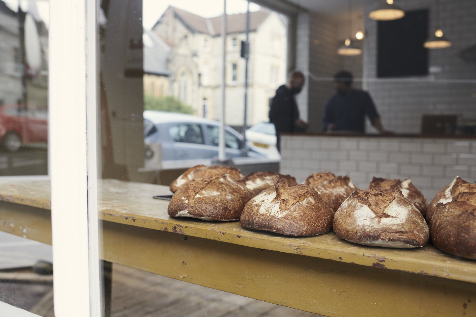 A bunch of loaves of bread are sitting on a table in a bakery.