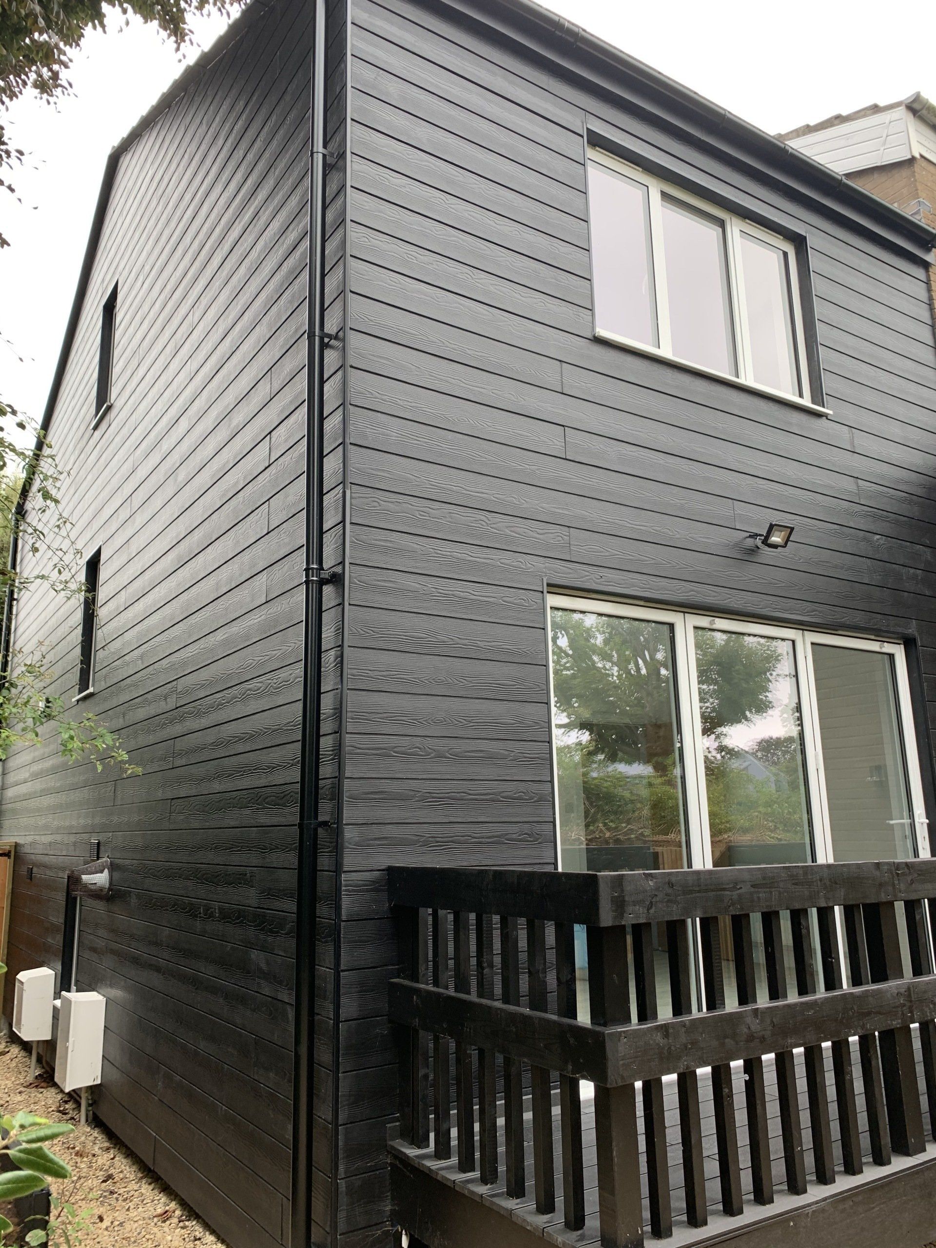 A black house with a balcony on the side of it.