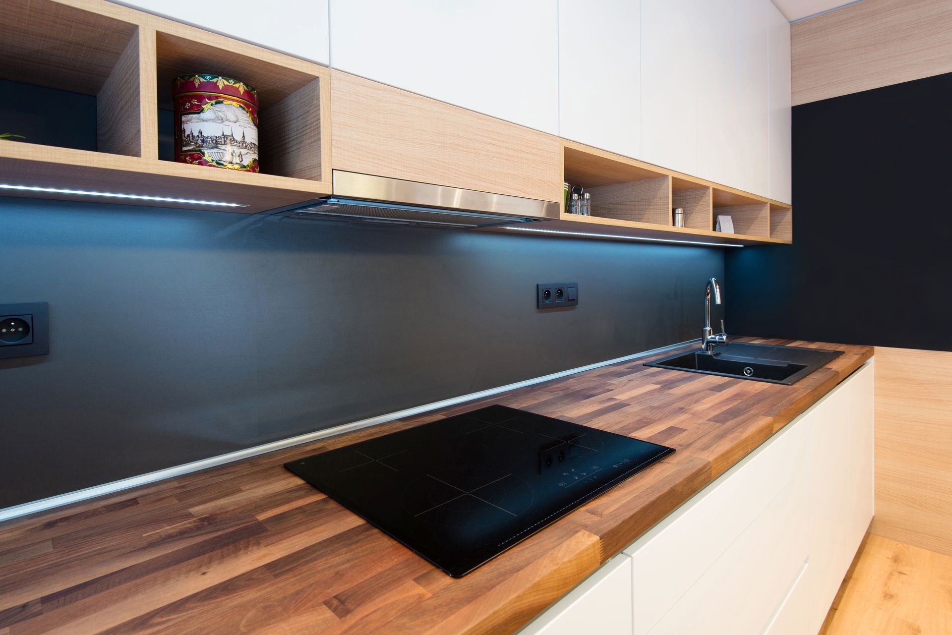 A kitchen with a wooden counter top and a black stove top oven.