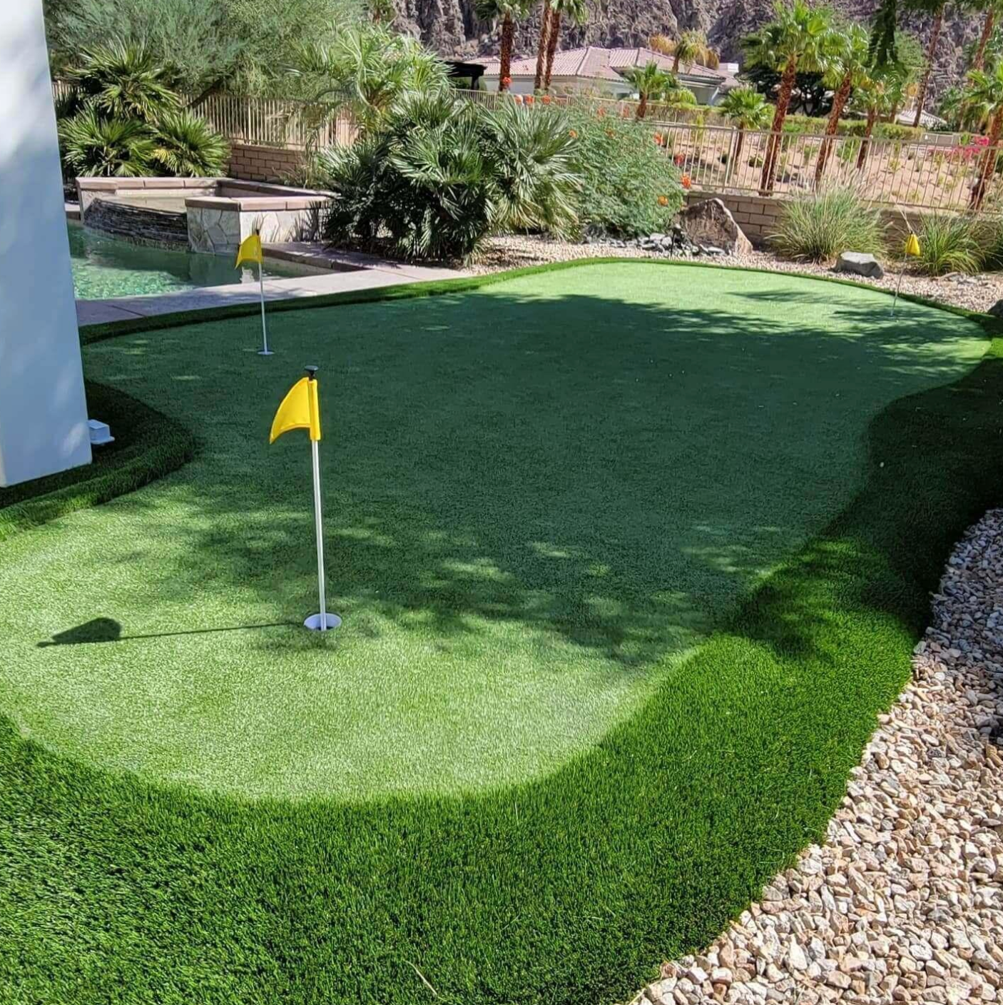 A golf course with a yellow flag on the green.