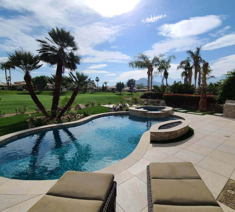 A large swimming pool with palm trees in the background