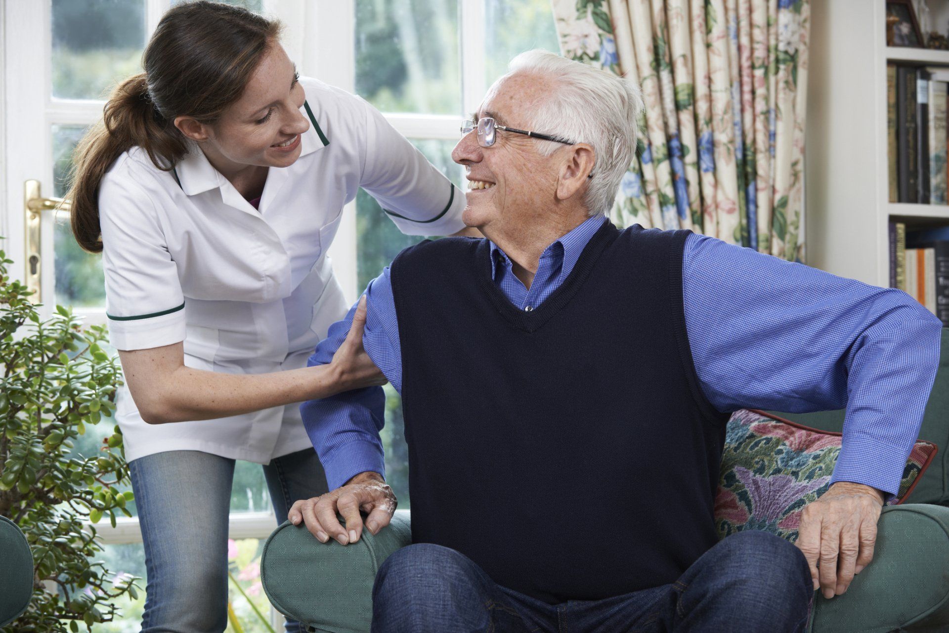 caregiver and elderly patient smiling at each other