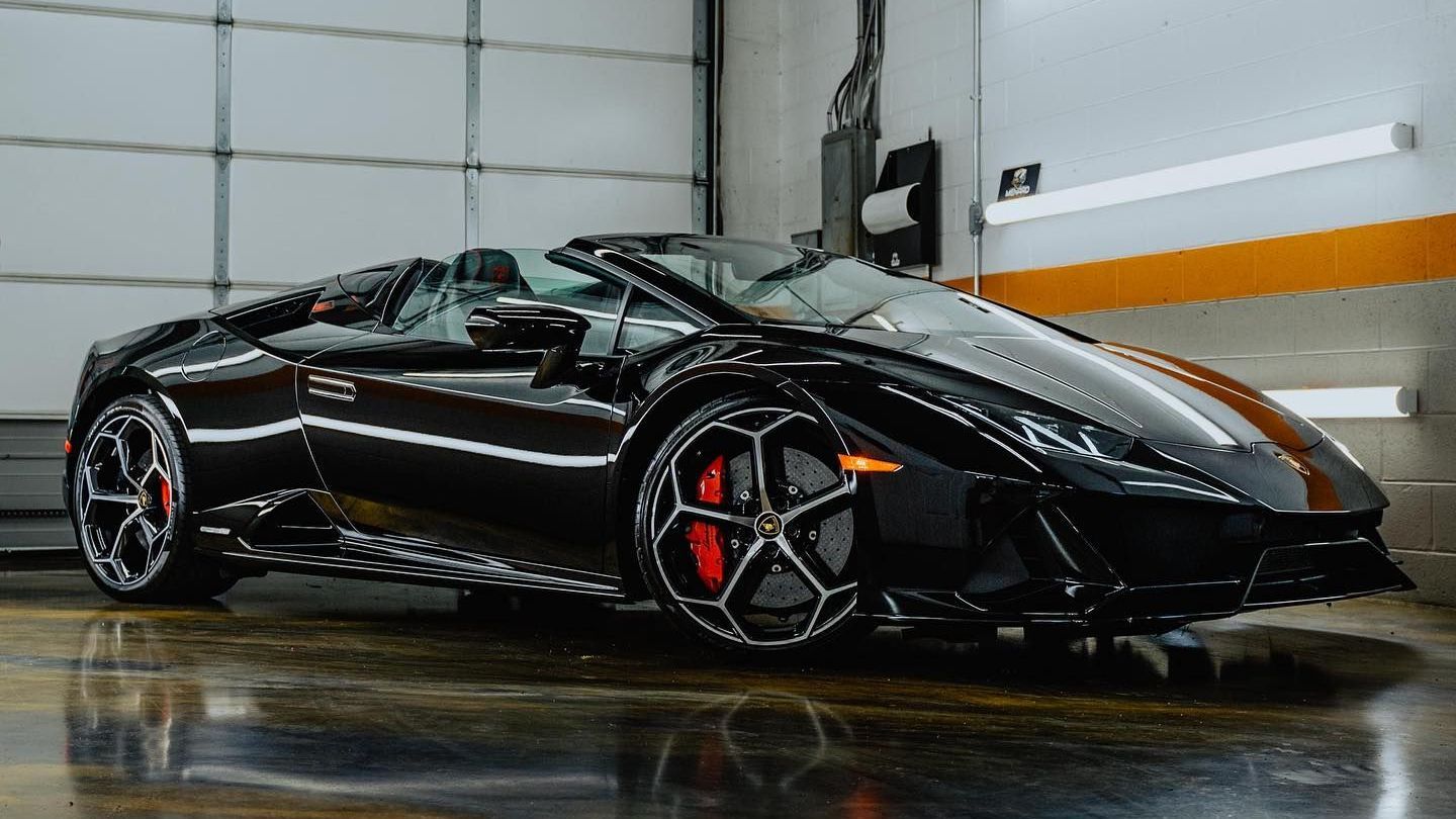 a black sports car is parked in a garage .