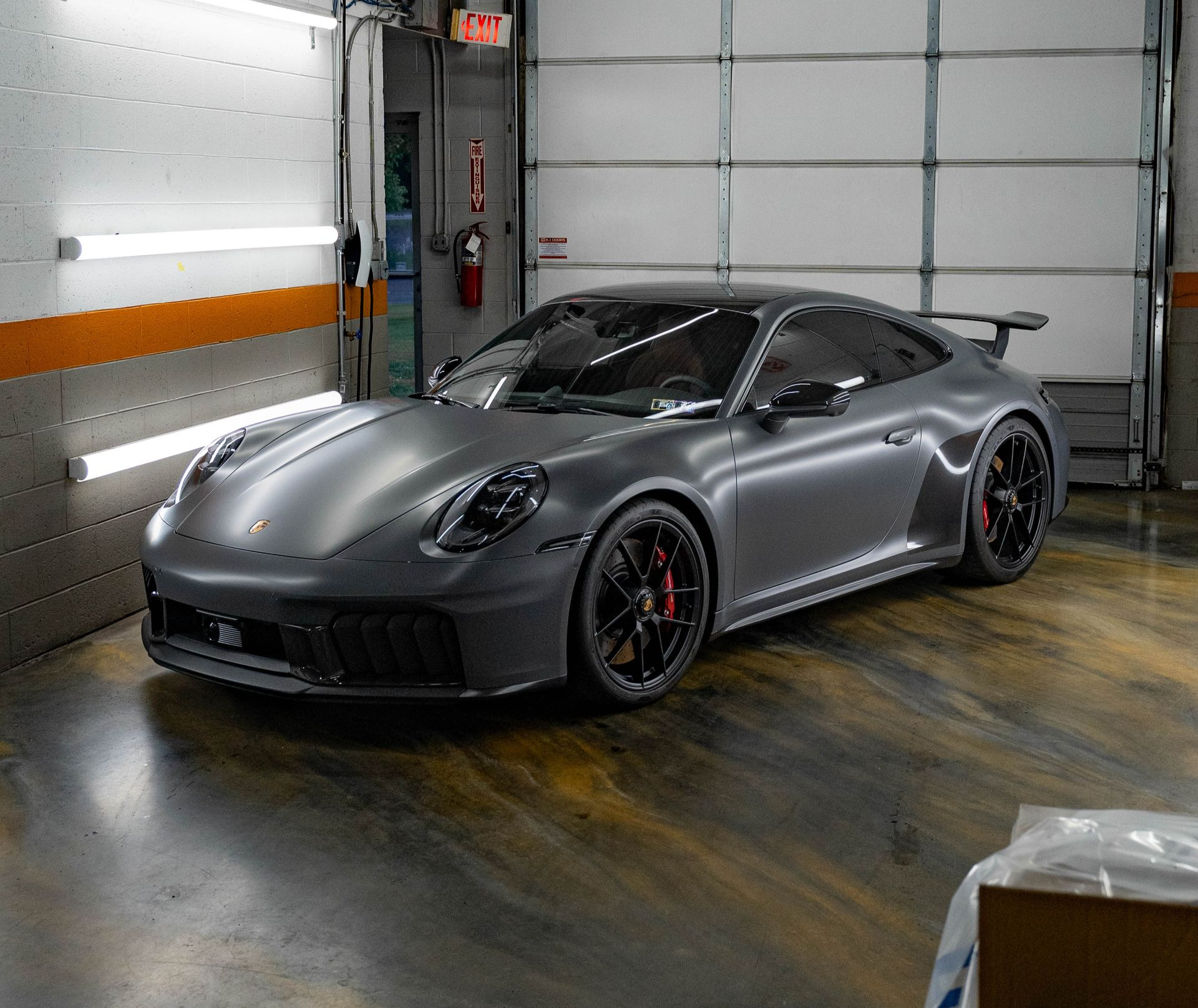 Close-up of a dark gray BMW SUV with a black grille, showing the front. The M logo is visible.