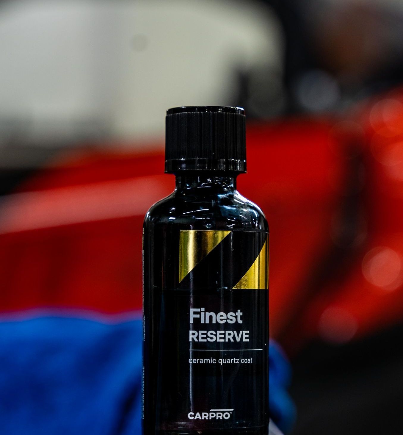 a bottle of polish is sitting on a table in front of a car .