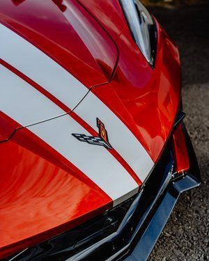 a close up of a red sports car with white stripes