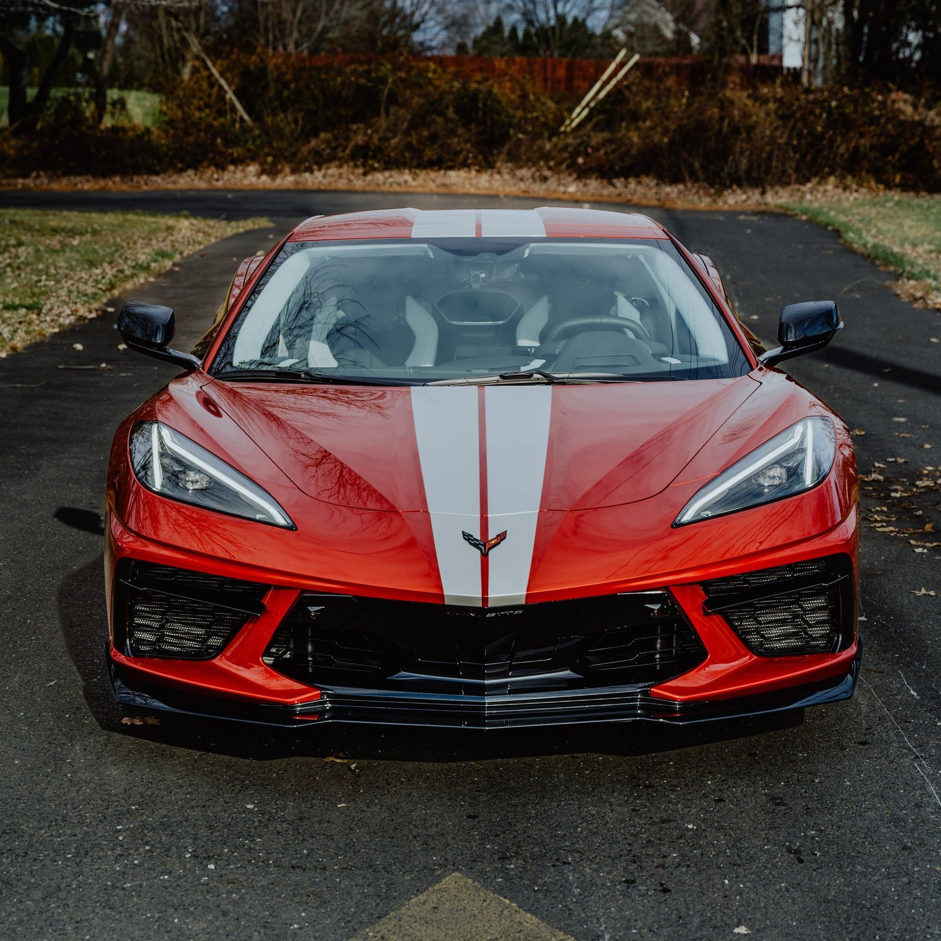 a red sports car is parked on the side of a road .