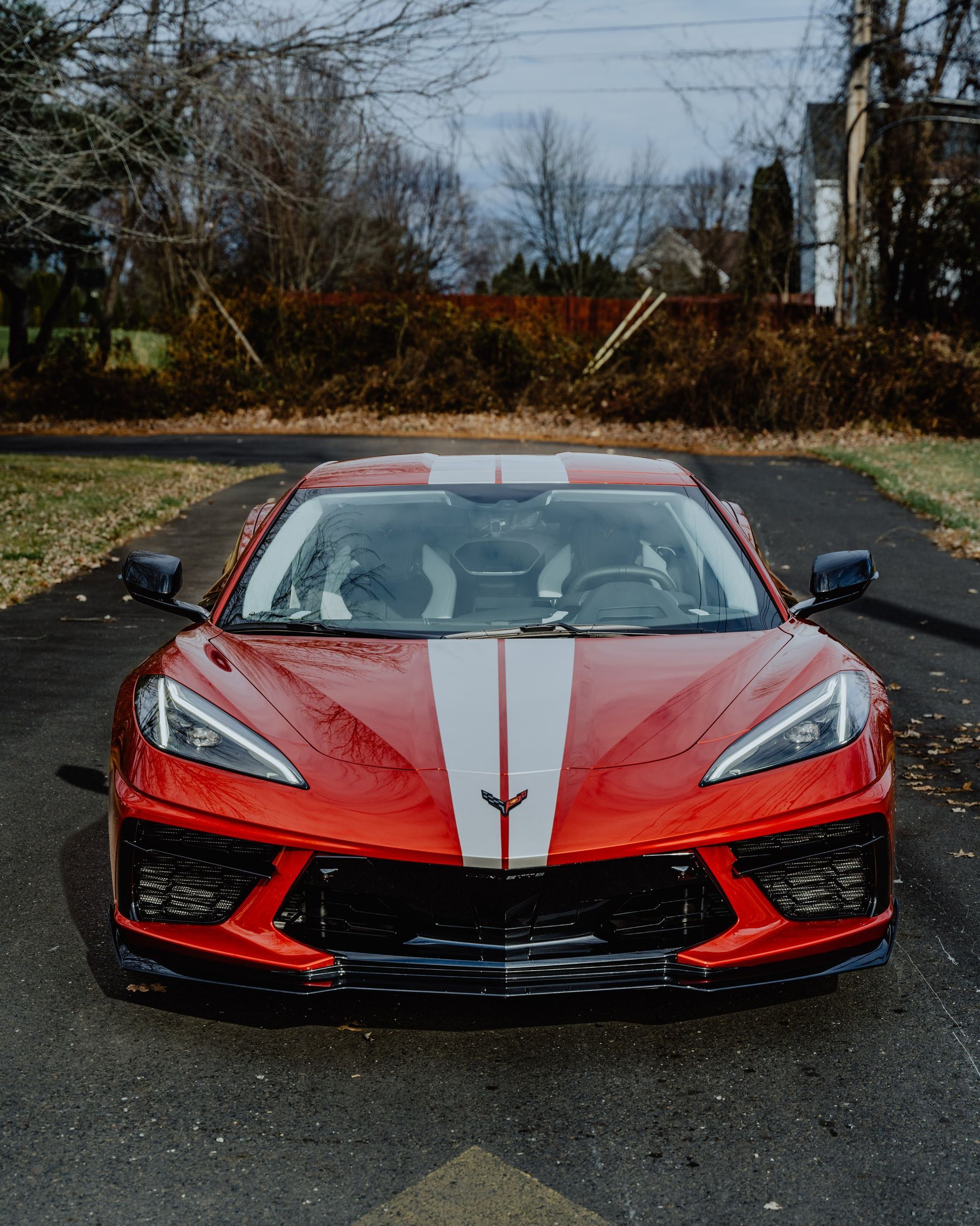 a man is working on a red sports car in a garage .