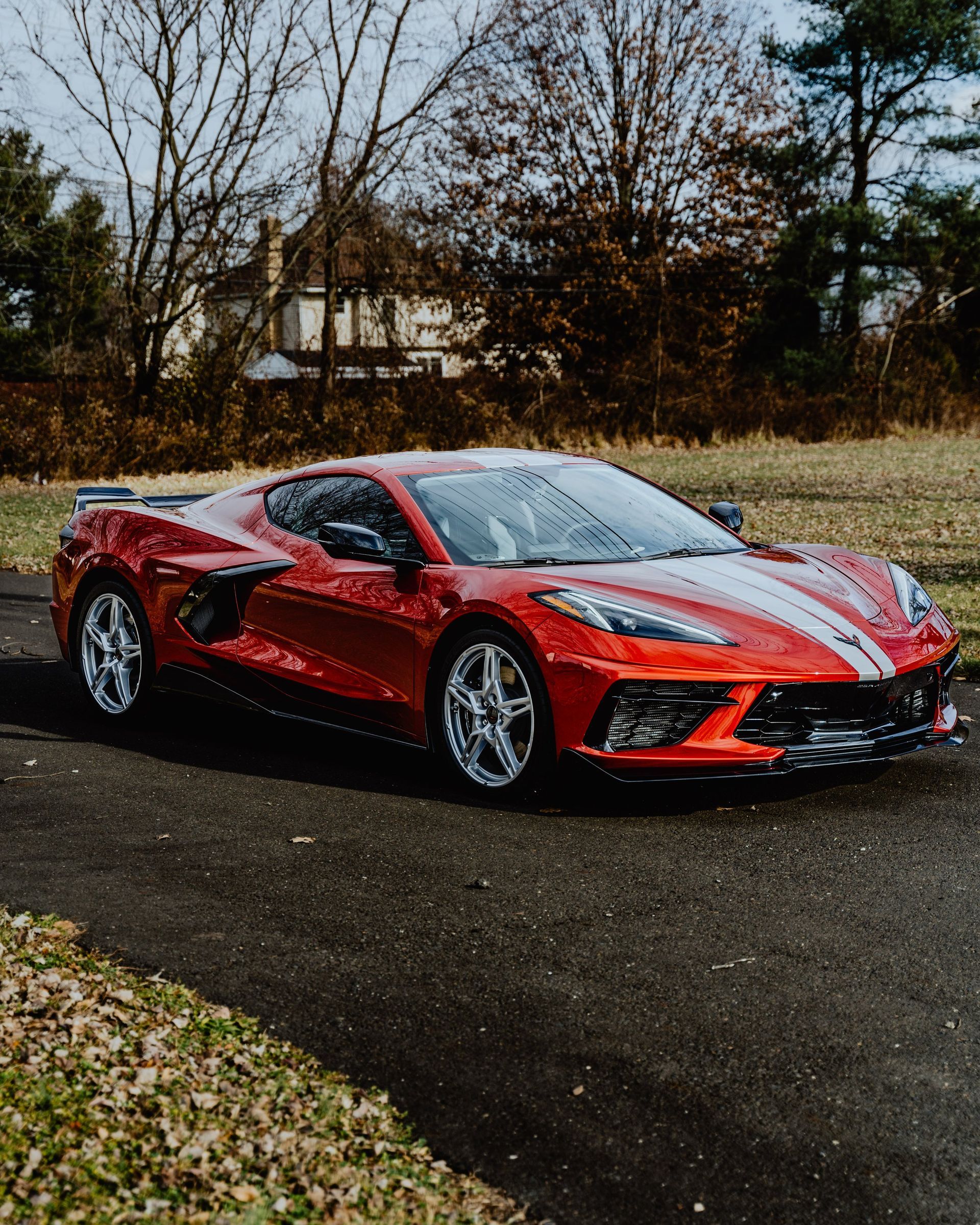 a red sports car is parked on the side of a road .