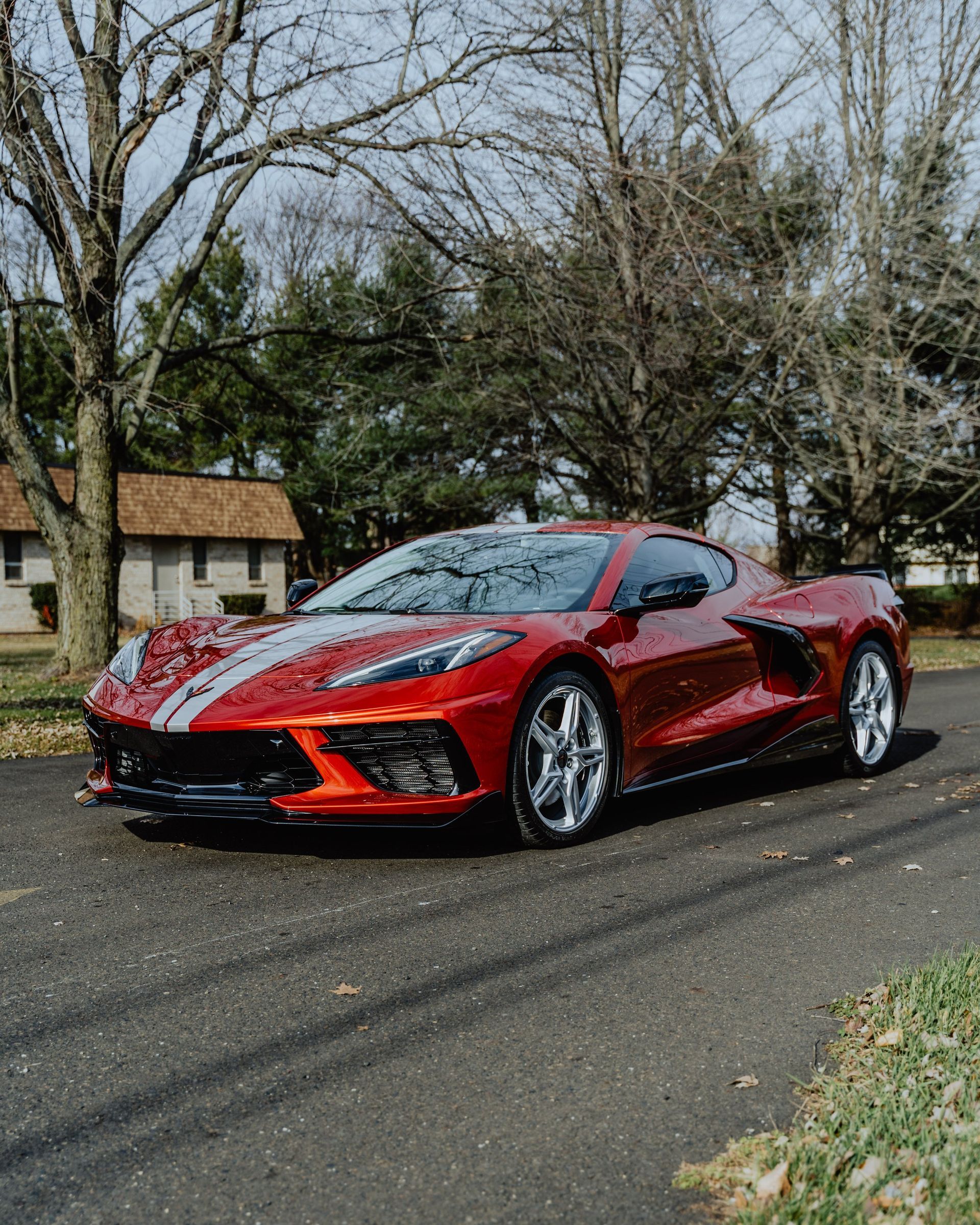 a red sports car is parked on the side of the road .