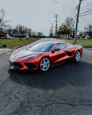 a red sports car is parked on the side of the road .