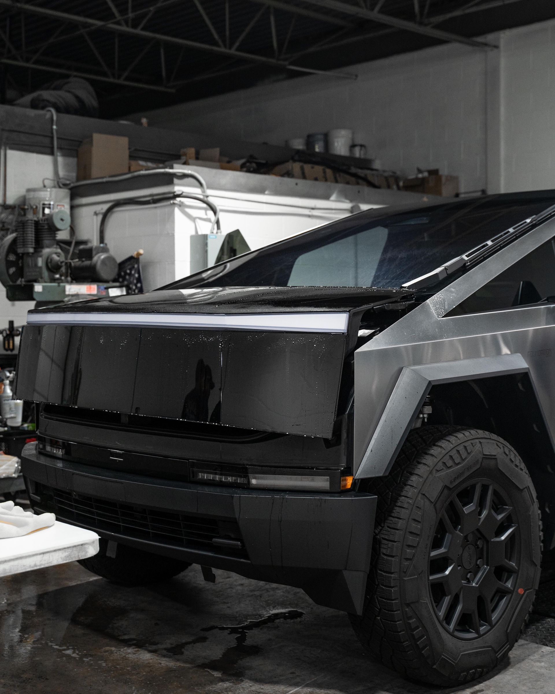 A black and silver truck is parked in a garage