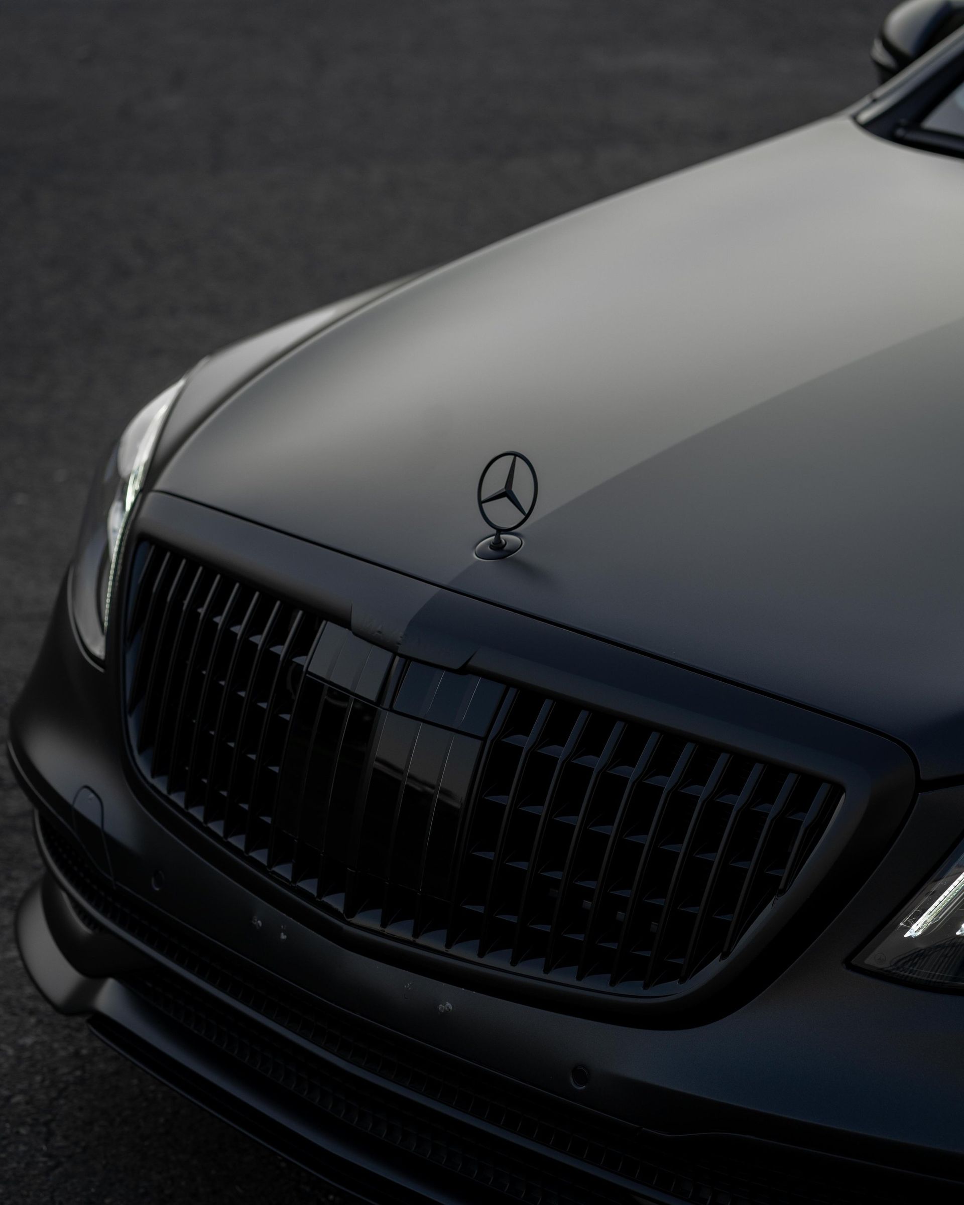 a close up of a black mercedes with a star on the hood
