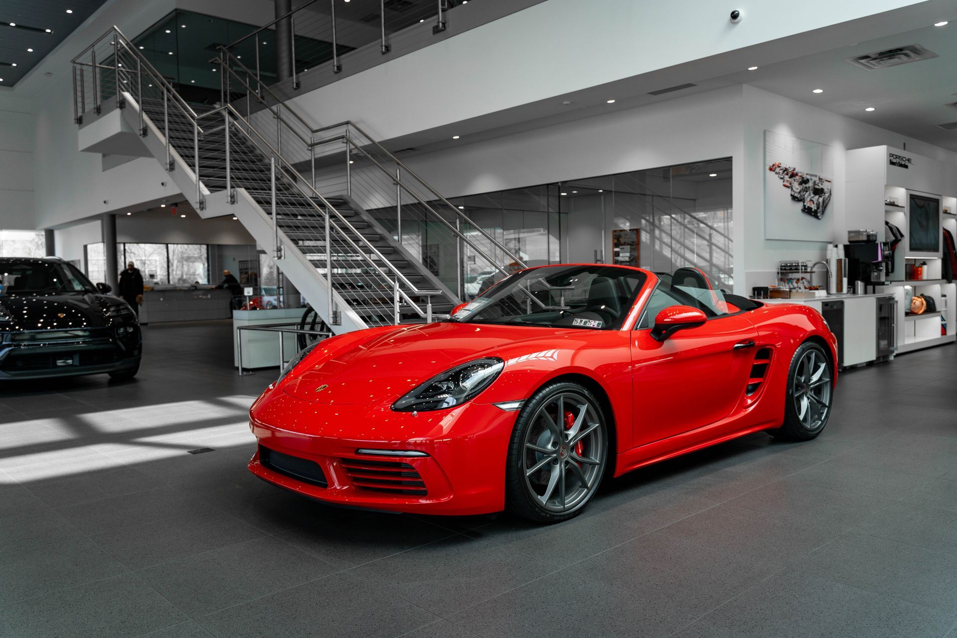 a silver porsche is parked in a garage next to a garage door .
