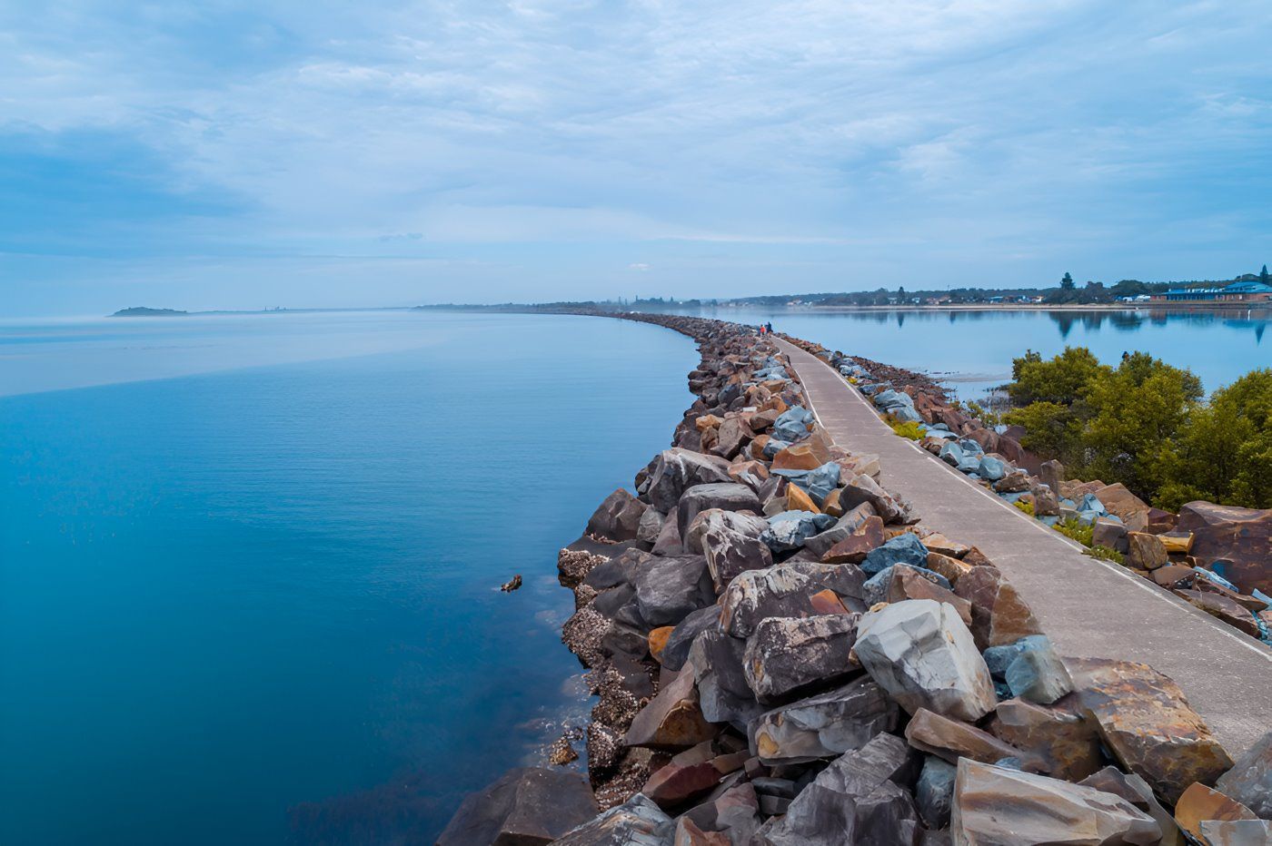 An Aerial View Of A Rocky Shoreline Next To A Body Of Water — HI PSI Hydraulics in Harrington, NSW