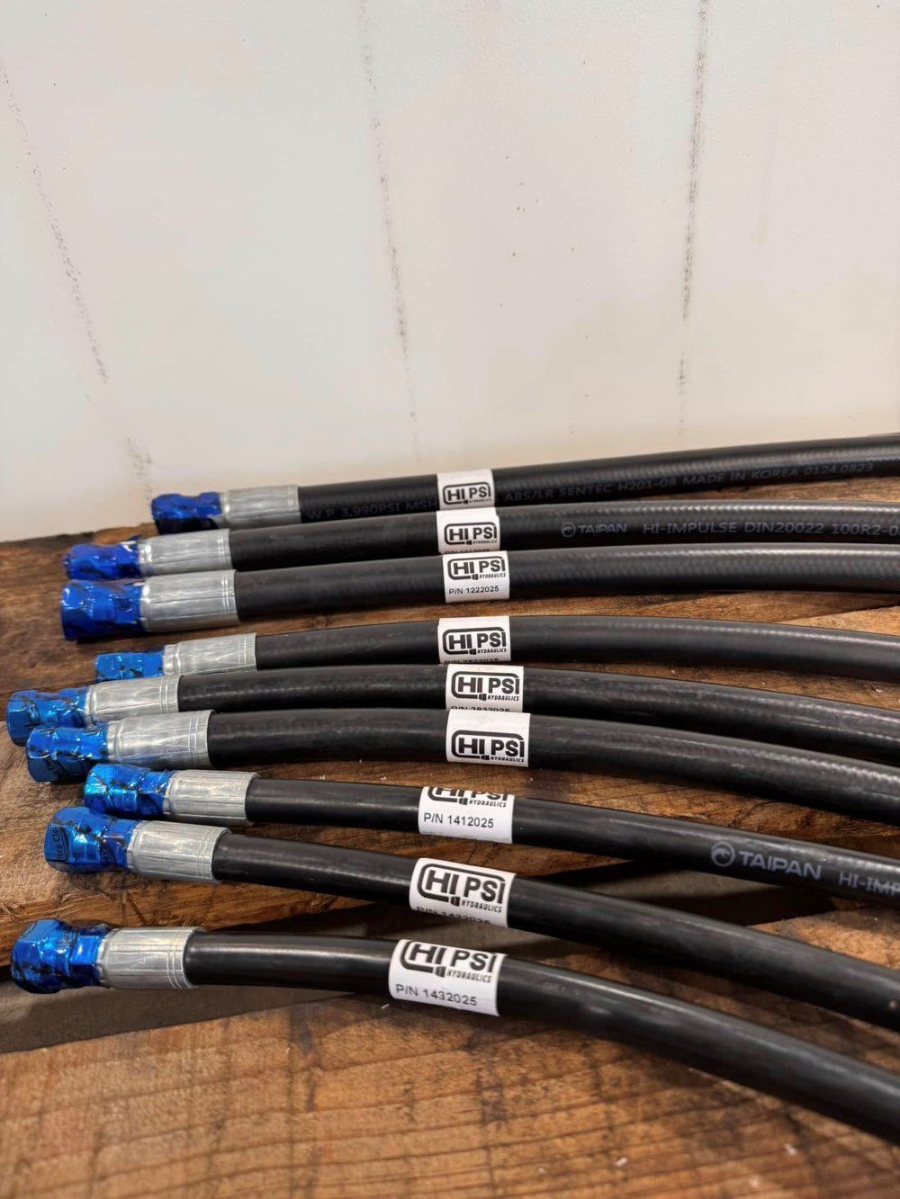 A Bunch Of Hose Sitting On Top Of A Wooden Table — HI PSI Hydraulics in Wauchope, NSW