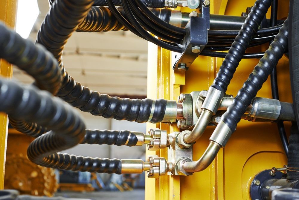 A Close Up Of Hydraulic Hoses On A Yellow Machine — HI PSI Hydraulics in Laurieton, NSW