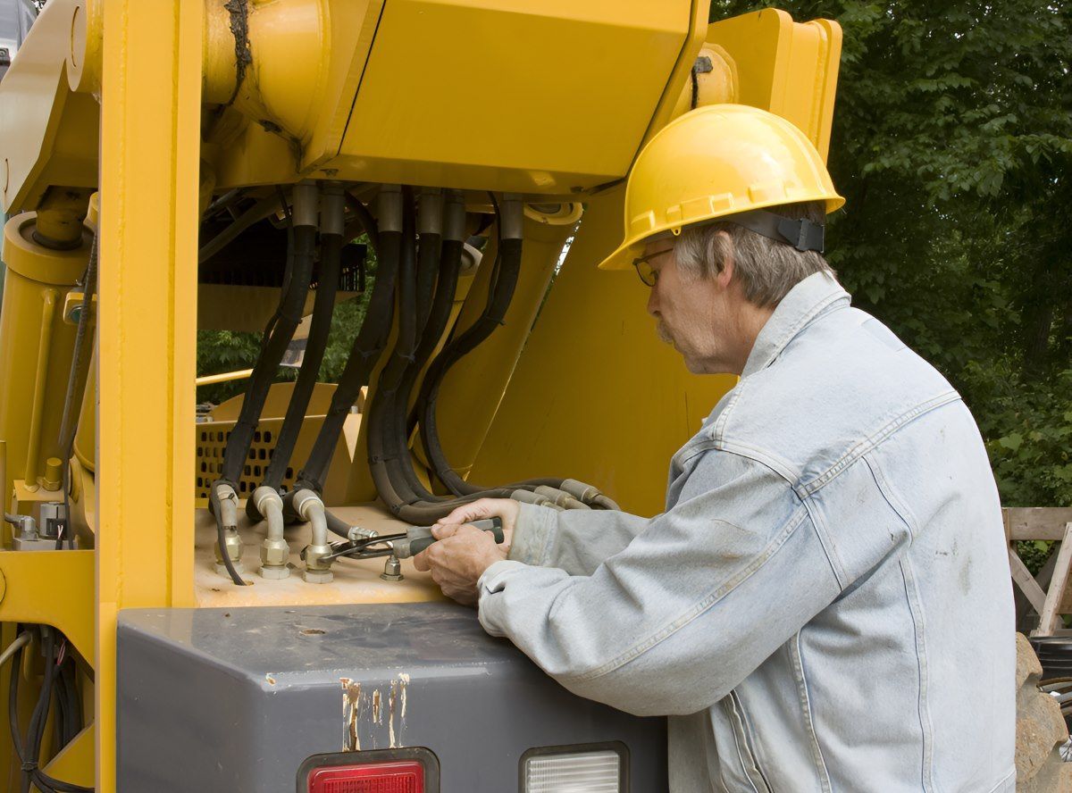 A Man Wearing A Hard Hat Is Working On A Yellow Machine — HI PSI Hydraulics in Laurieton, NSW