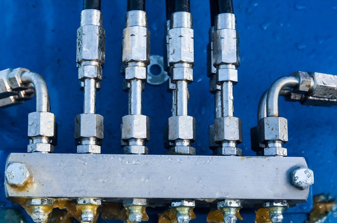 A Bunch Of Hydraulic Hoses Are Connected To A Metal Block On A Blue Surface — HI PSI Hydraulics in Harrington, NSW