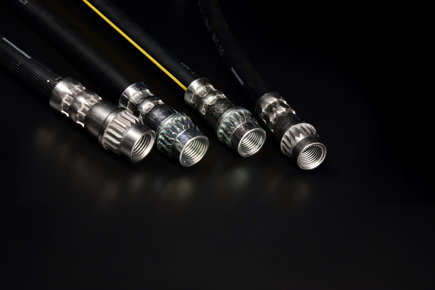 A Close Up Of Four Hose Connectors On A Black Surface — HI PSI Hydraulics in Taree, NSW