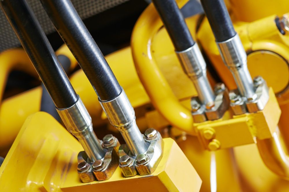 A Close Up Of Hydraulic Hoses On A Yellow Machine — HI PSI Hydraulics in Taree, NSW