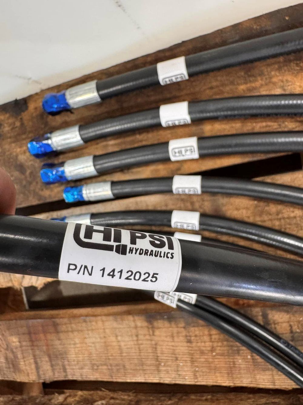Five black hydraulic hoses with white labels, and blue caps — HI PSI Hydraulics in Wauchope, NSW