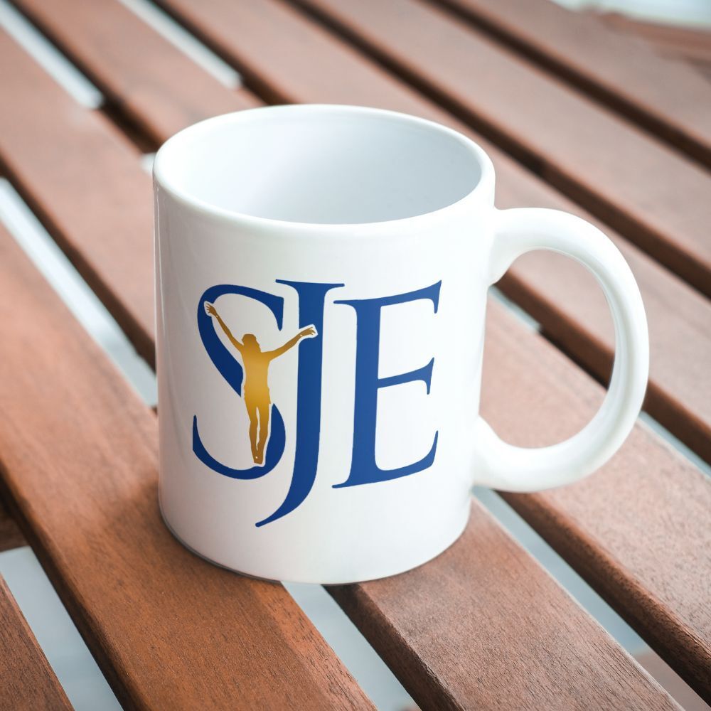 A white coffee mug with the letters sje on it