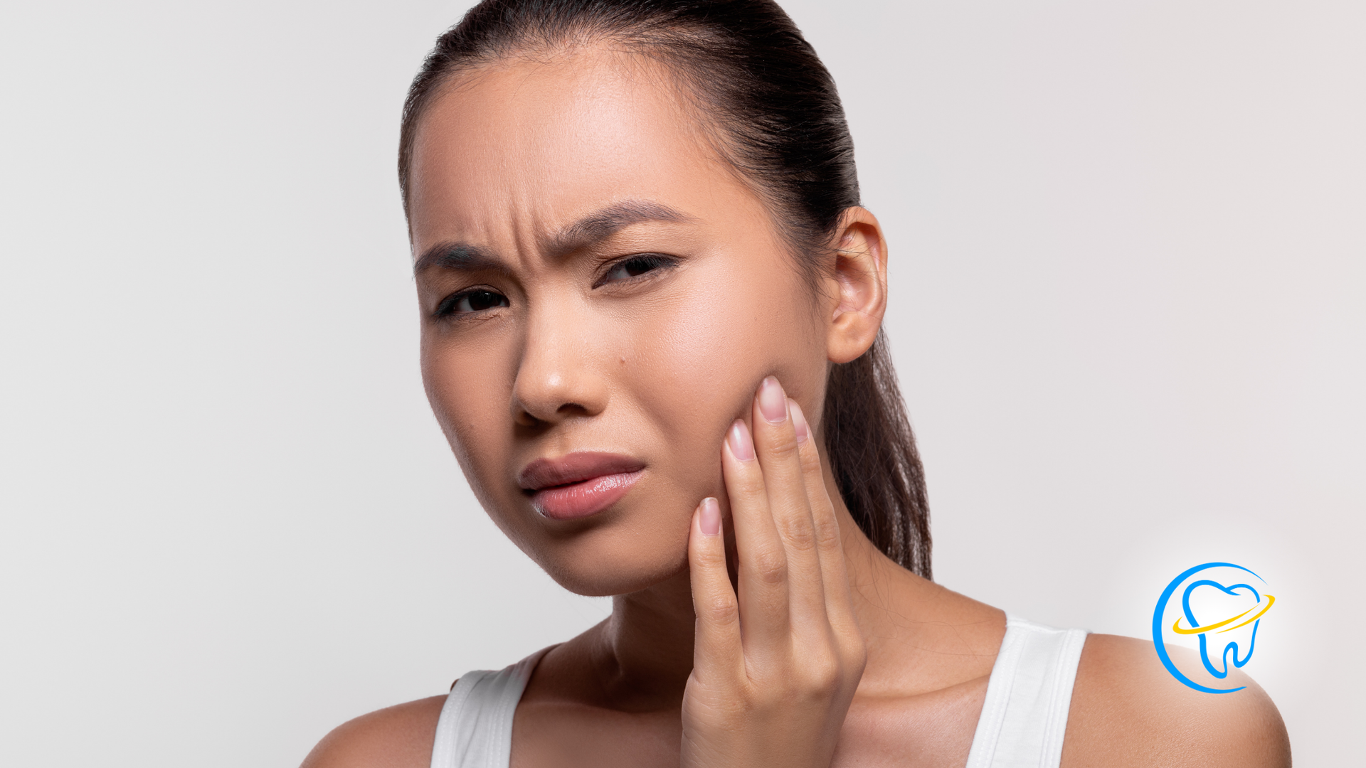 A woman is holding her face in pain because of a toothache.