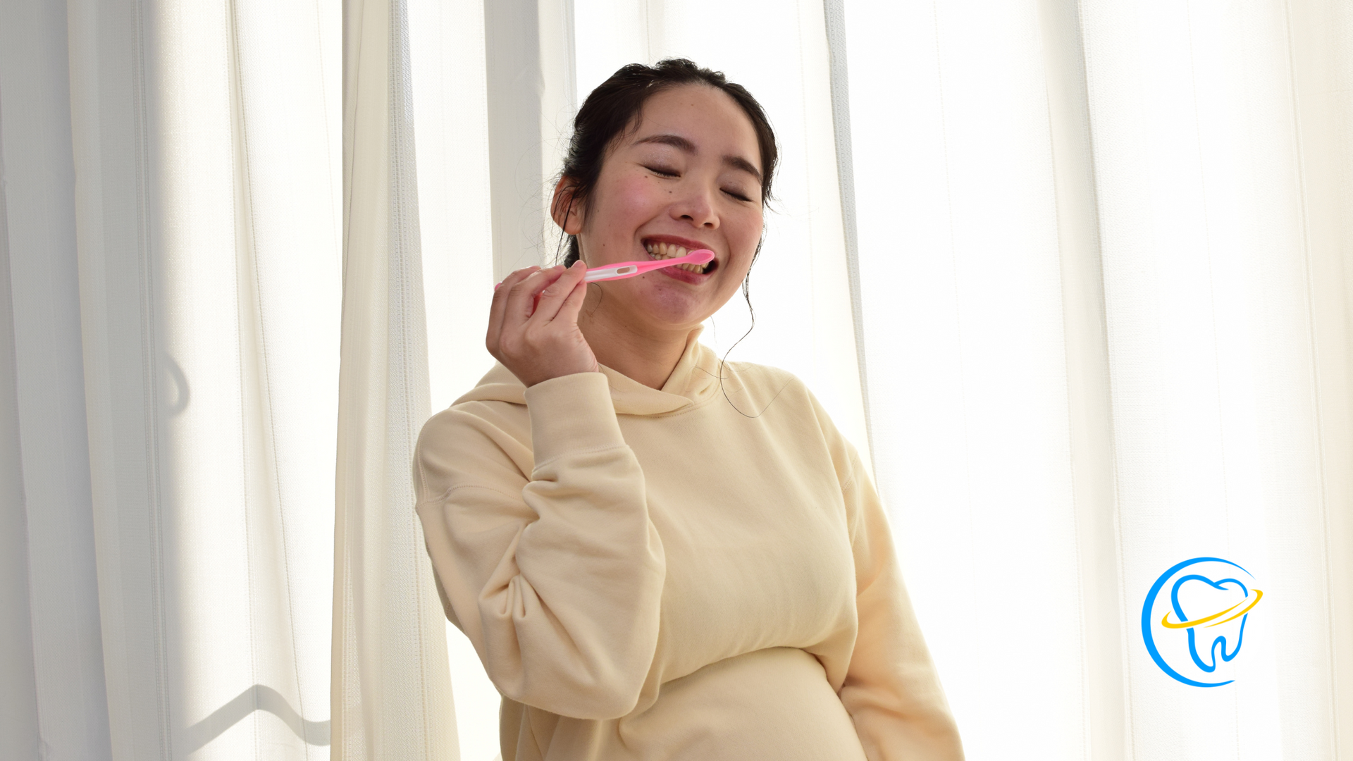 A pregnant woman is brushing her teeth with a pink toothbrush.