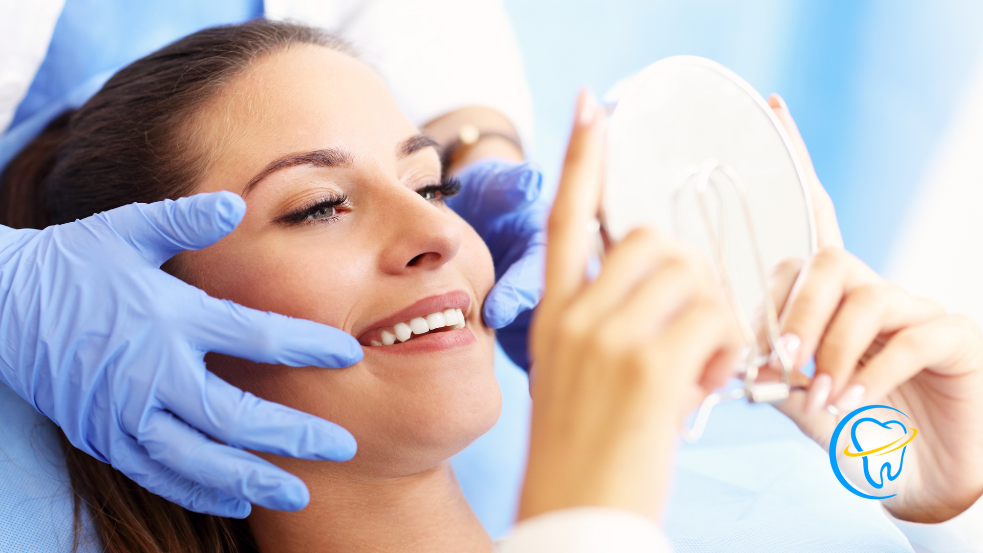 A woman is looking at her teeth in a mirror at the dentist.