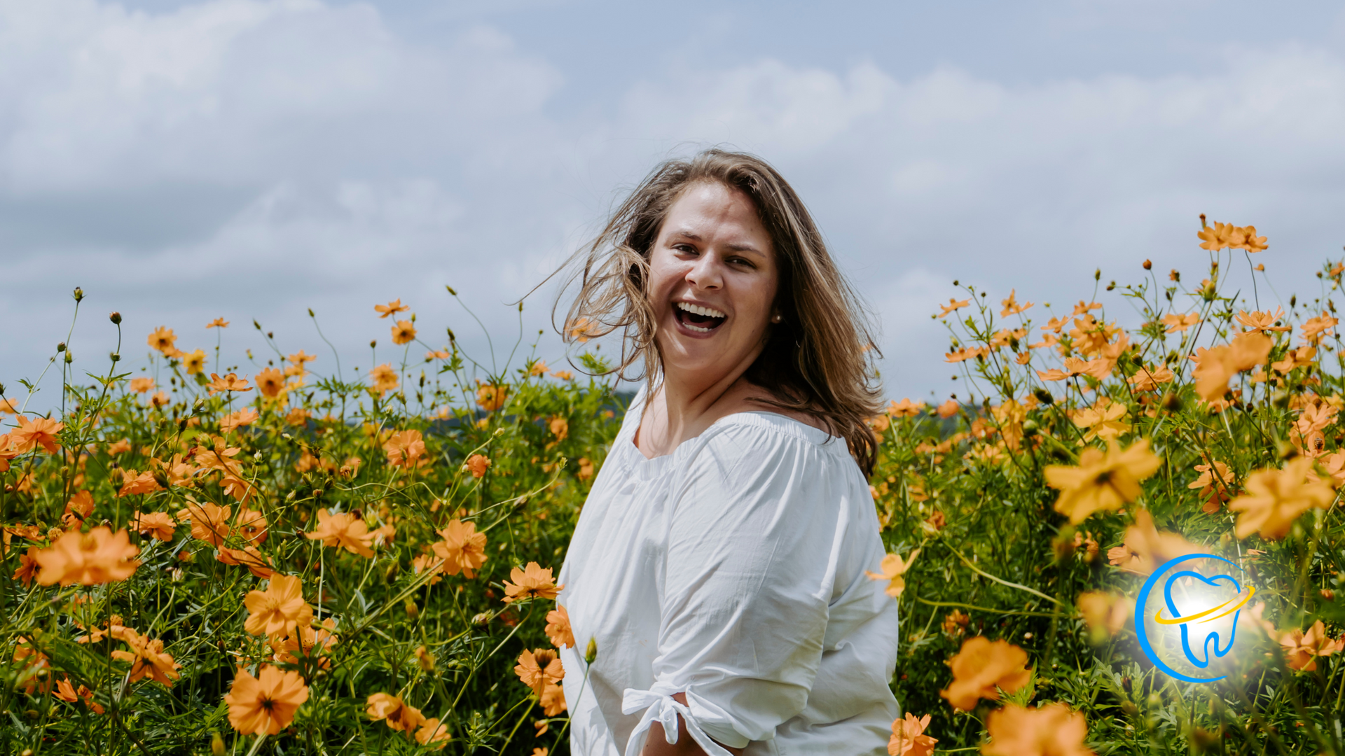 A woman in a white shirt is standing in a field of yellow flowers.