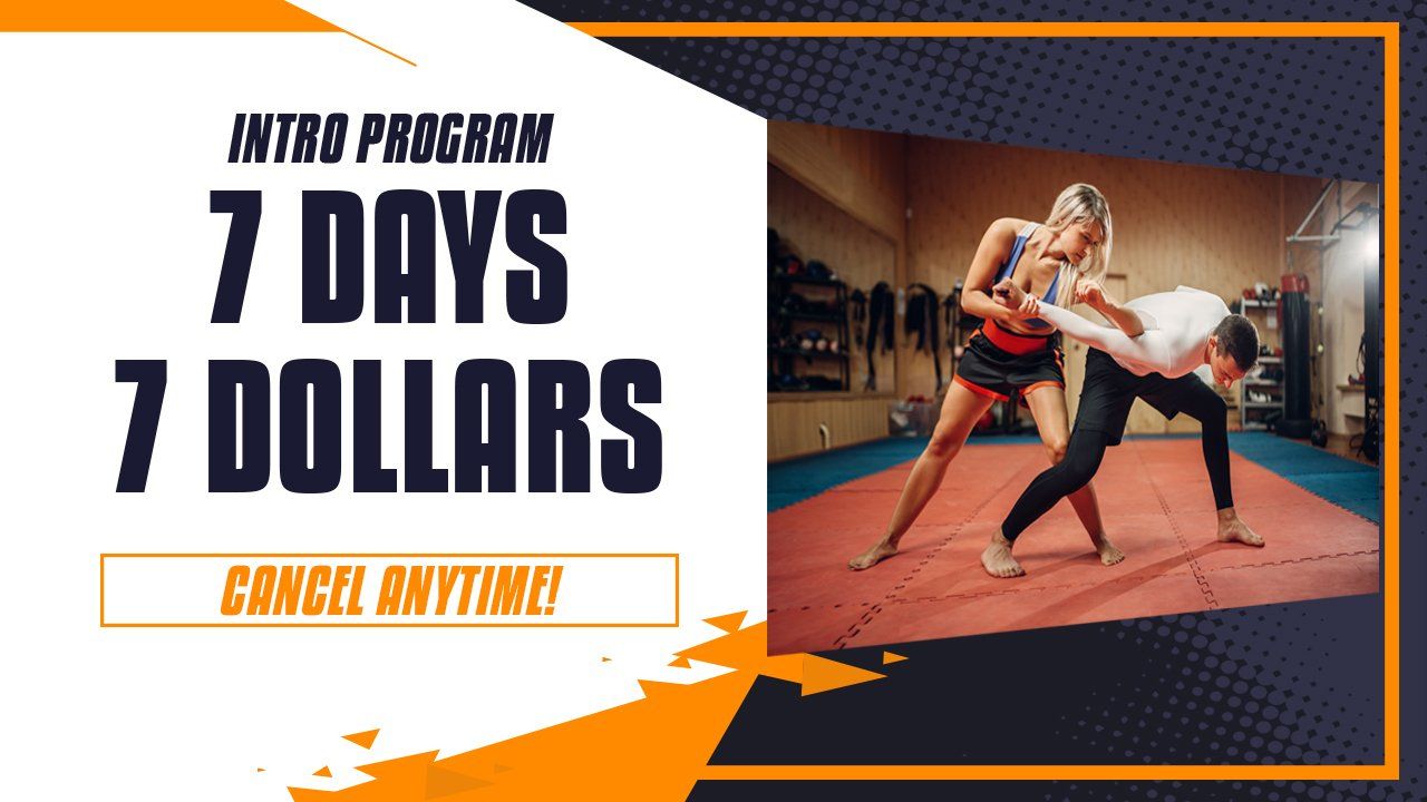 A man and a woman are fighting on a mat in a gym.