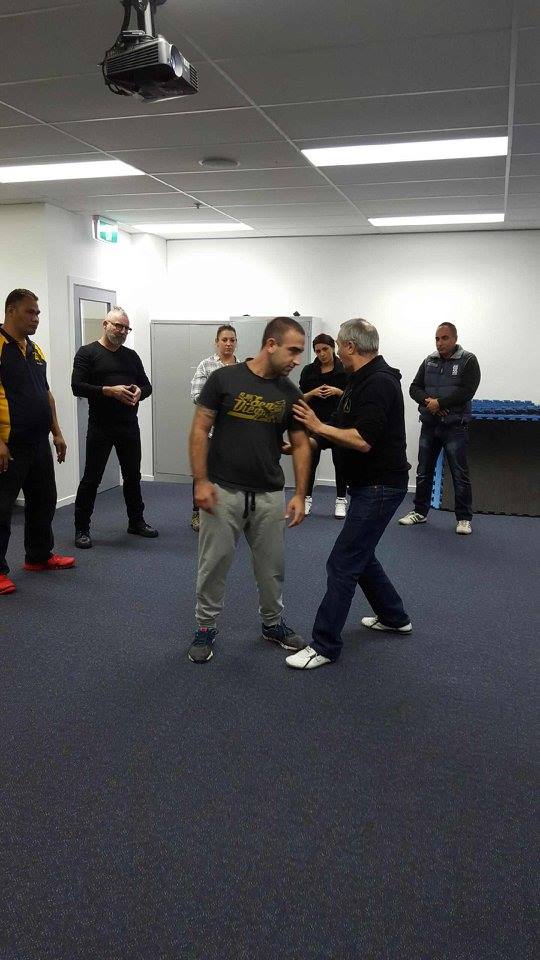 A group of men are practicing martial arts in a room.