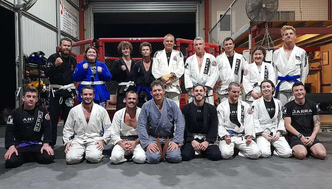A group of people in karate uniforms are posing for a picture.