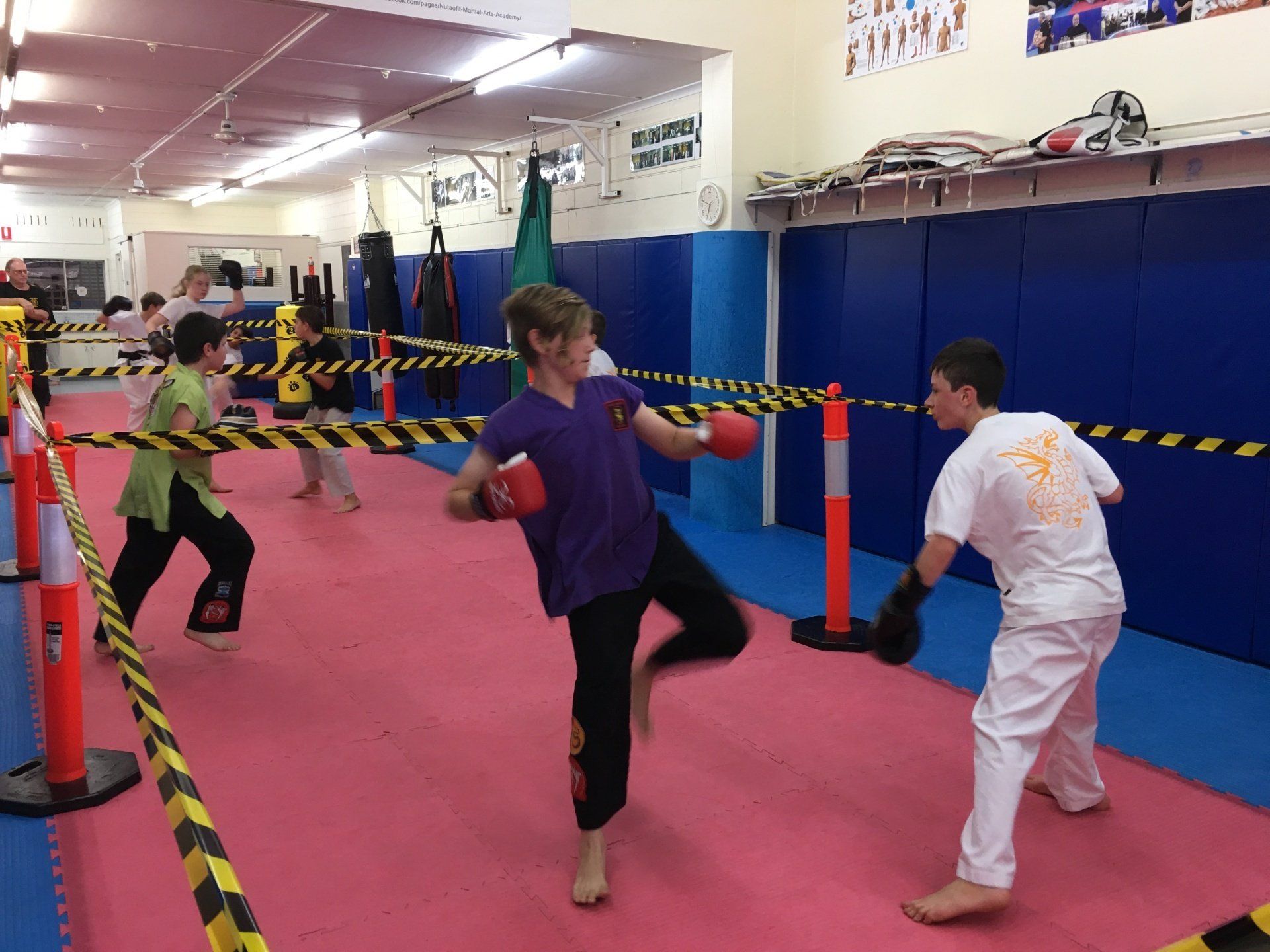 A group of children are practicing martial arts in a gym