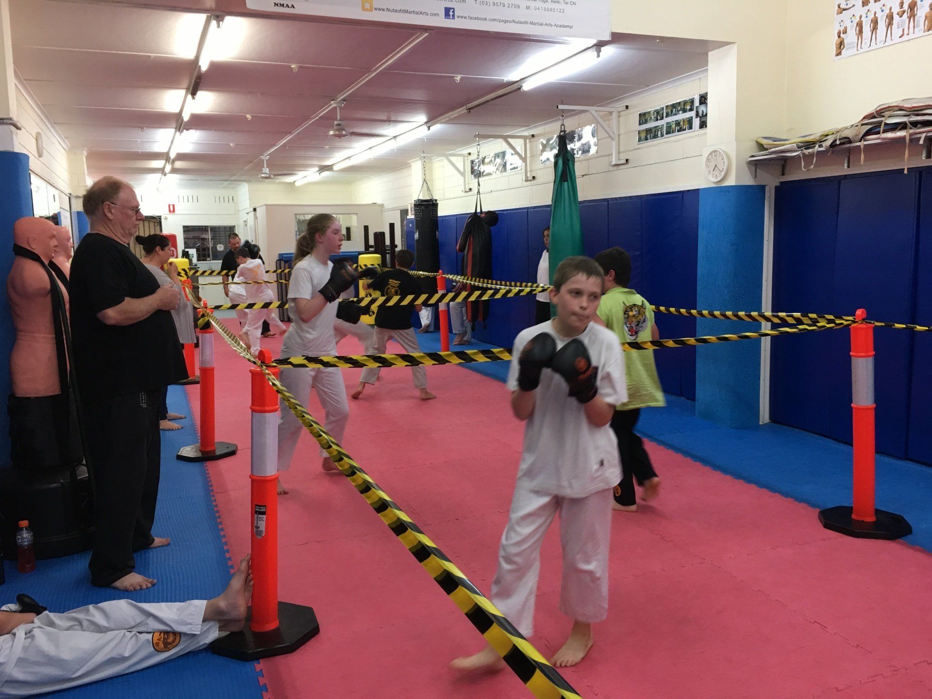 A group of people are practicing martial arts in a gym.