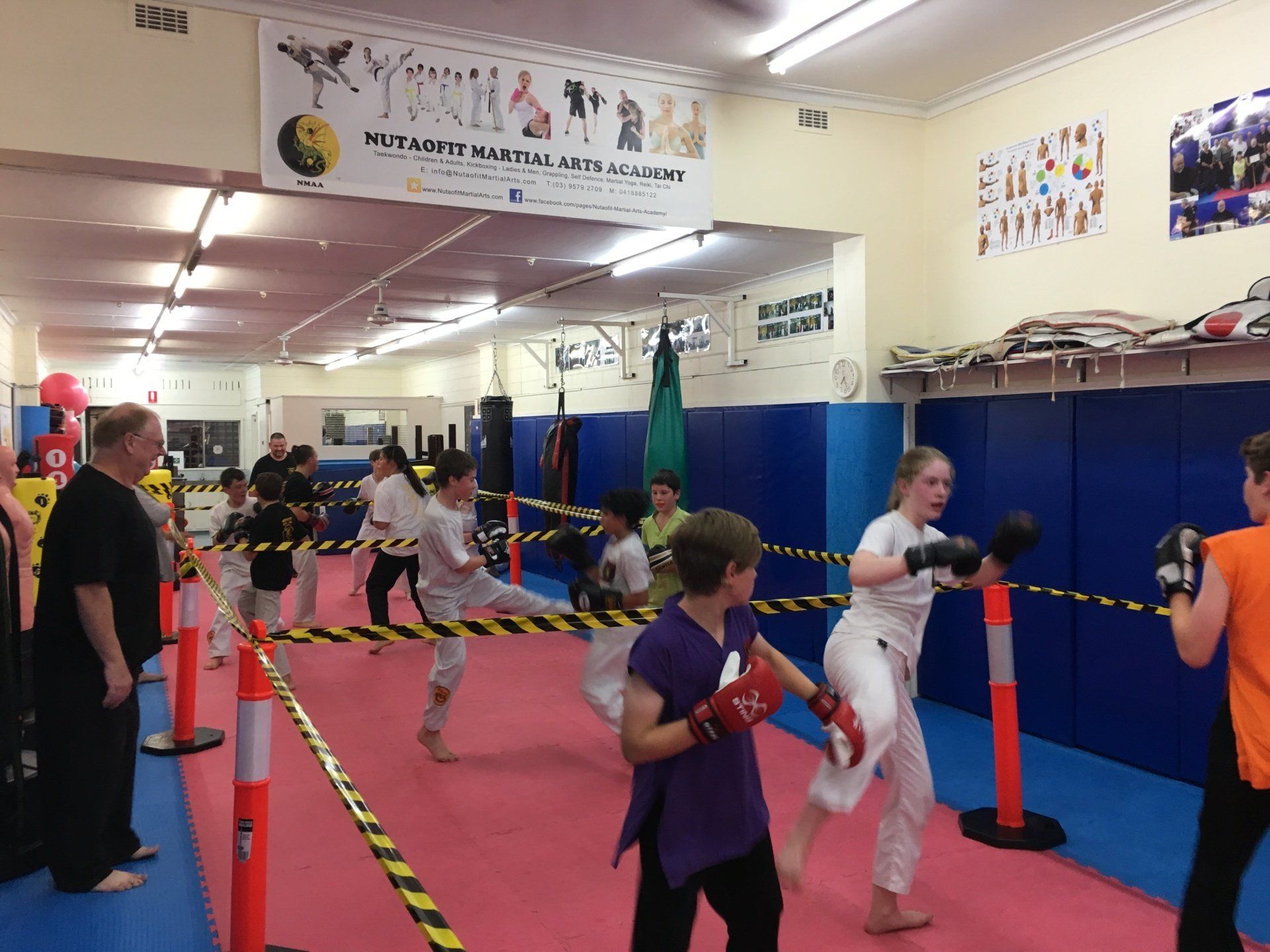A group of kids are practicing martial arts in a gym