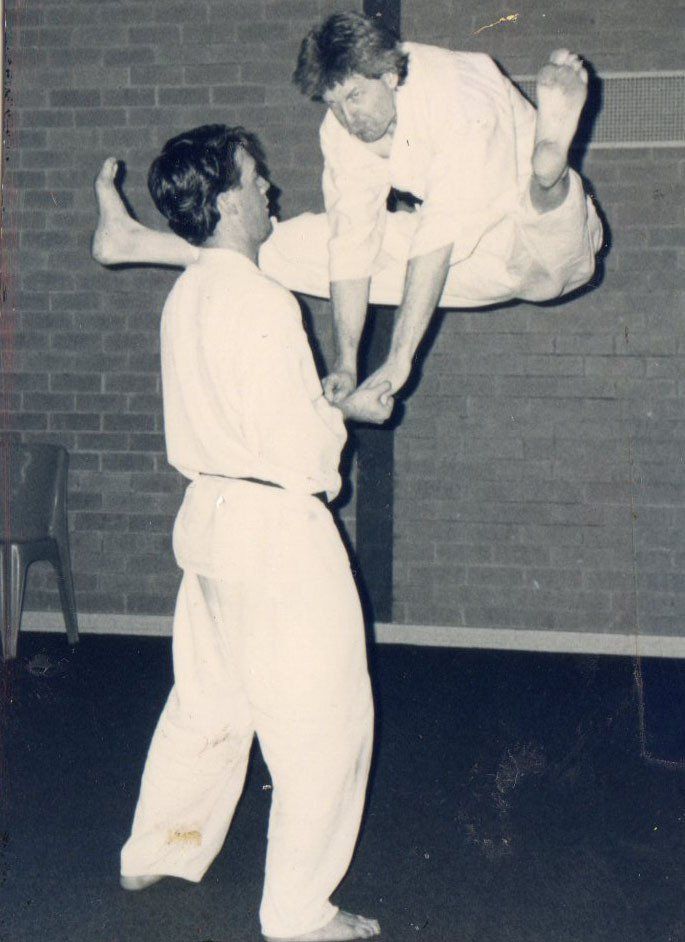 A black and white photo of two men practicing martial arts