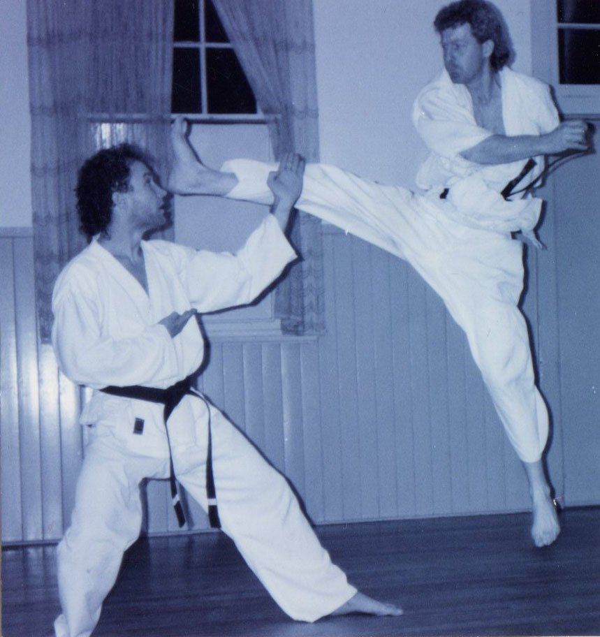 Two men are practicing martial arts in a room