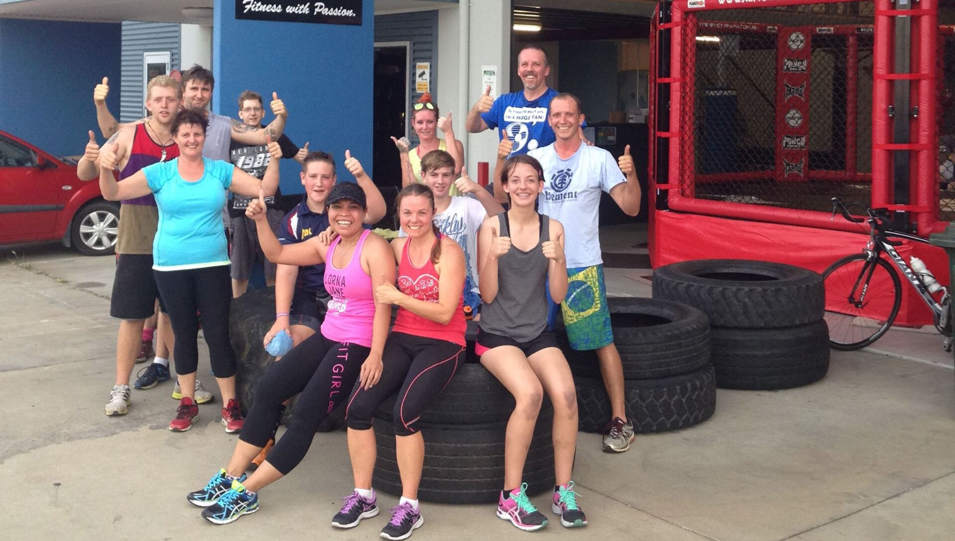 A group of people are posing for a picture while sitting on tires.