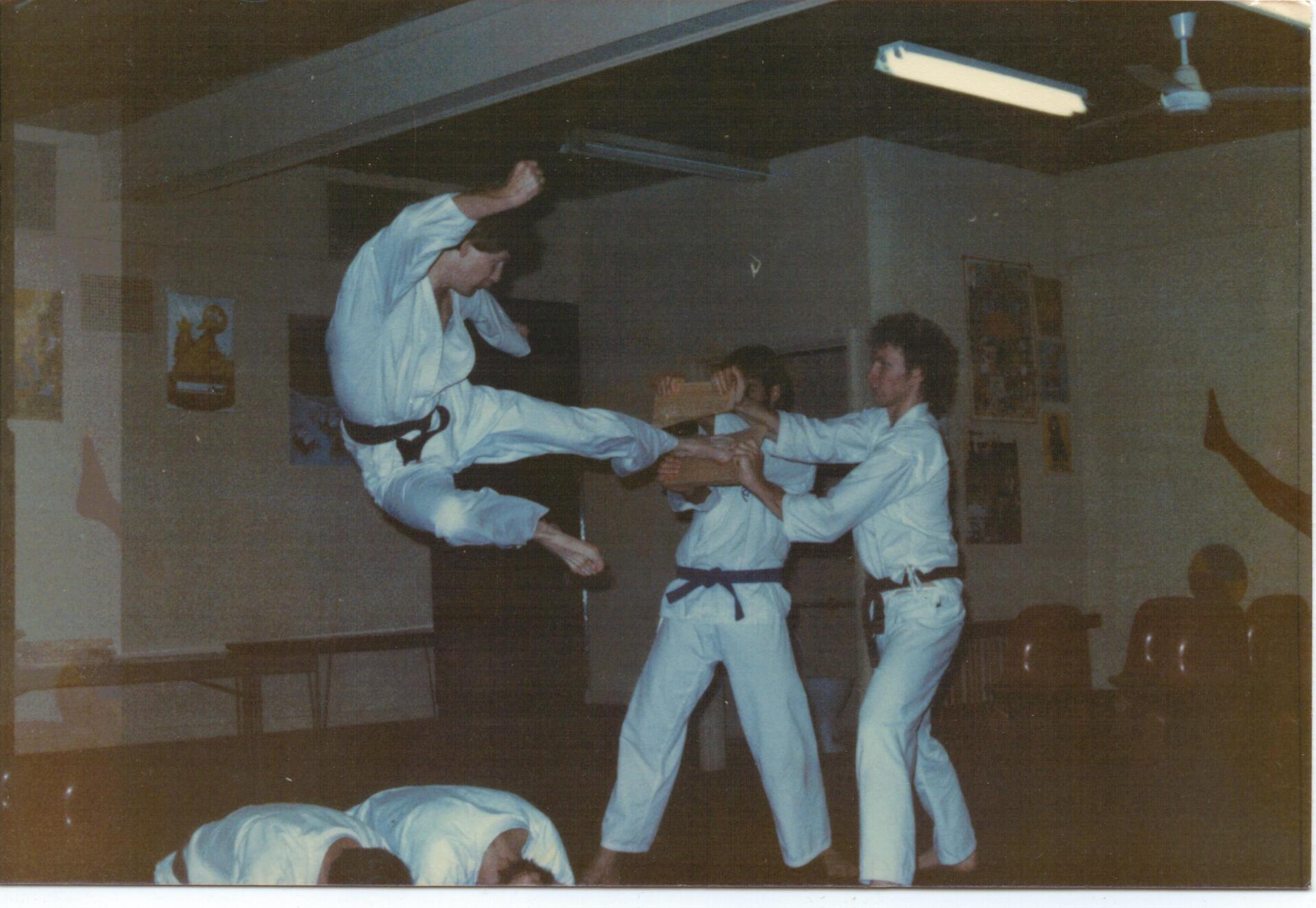A group of people are practicing martial arts in a gym