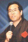 A man wearing glasses is holding a microphone in his hand.