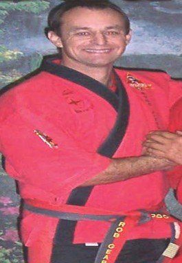 A man in a red and black karate uniform with a belt that says 200 on it
